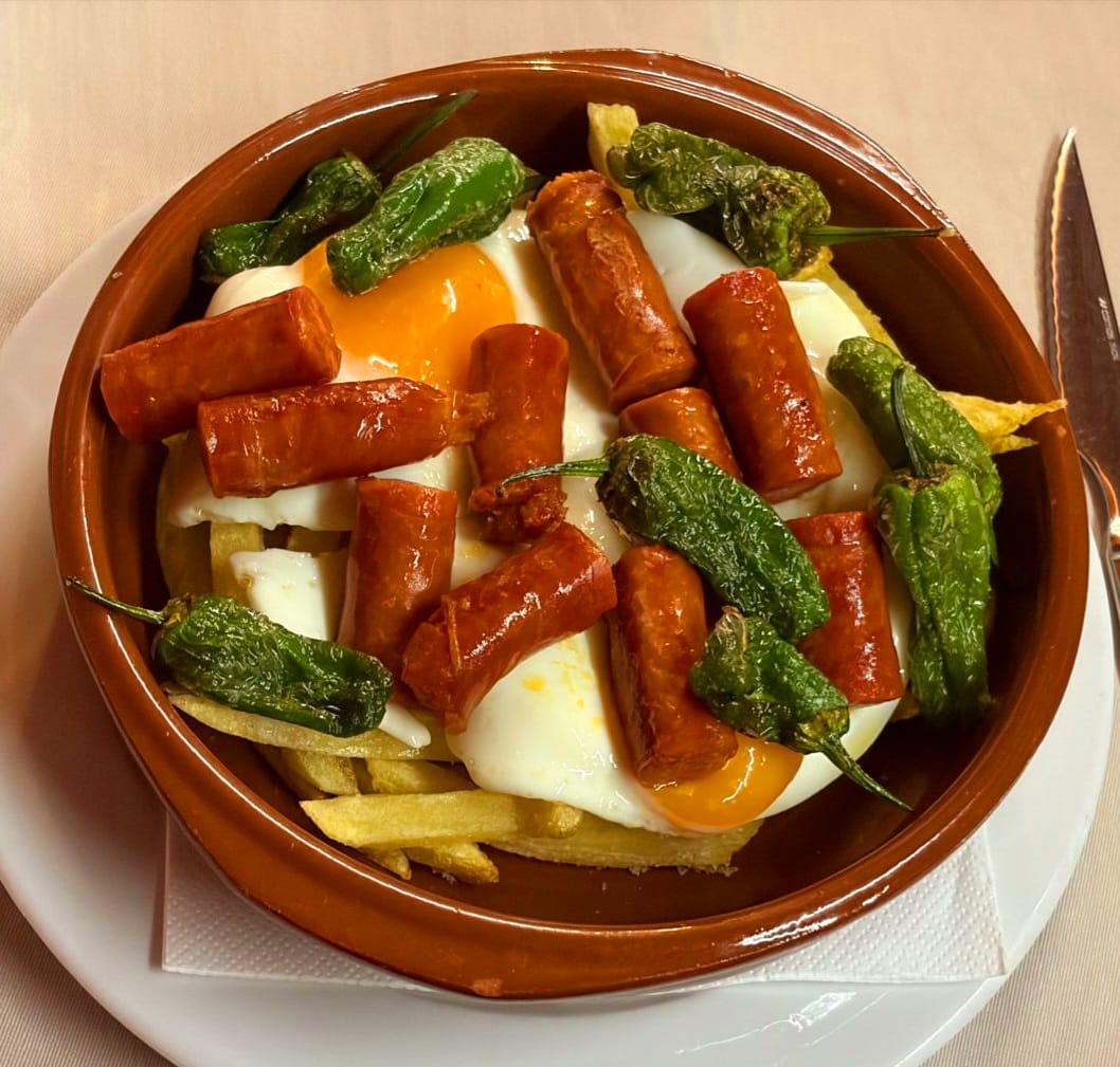 CAZUELA DE HUEVOS ROTOS CON CHISTORRA DE LEÓN Y PIMIENTOS DE PADRÓN en Matalafer